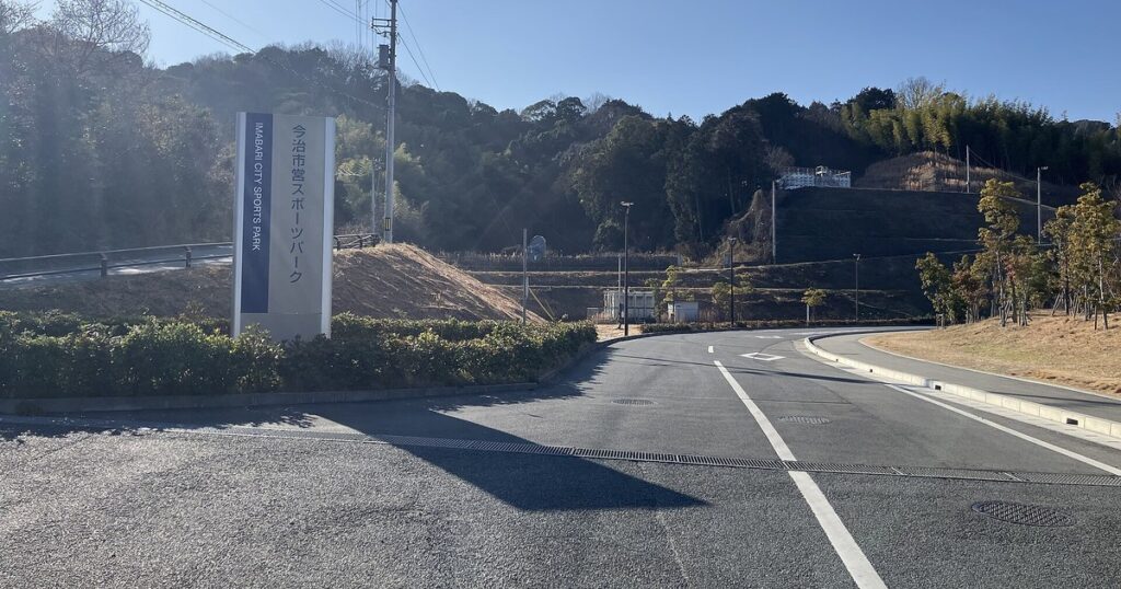 今治市営スポーツパークの入口。看板と背後の山