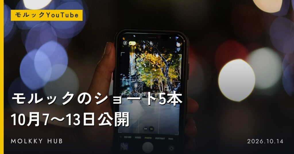 夜の光のぼかしを背に、縦向きに持ったスマートフォンで撮影しているところ。写真はイメージです